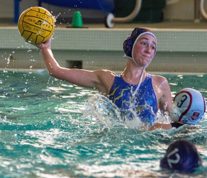 Female athlete about to throw the ball in a water polo competition
